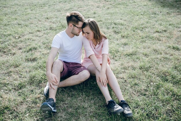 Couple assis sur la pelouse avec amour