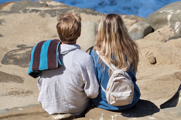 Un couple assis sur les rochers et regardant l'océan de San Diego, USA