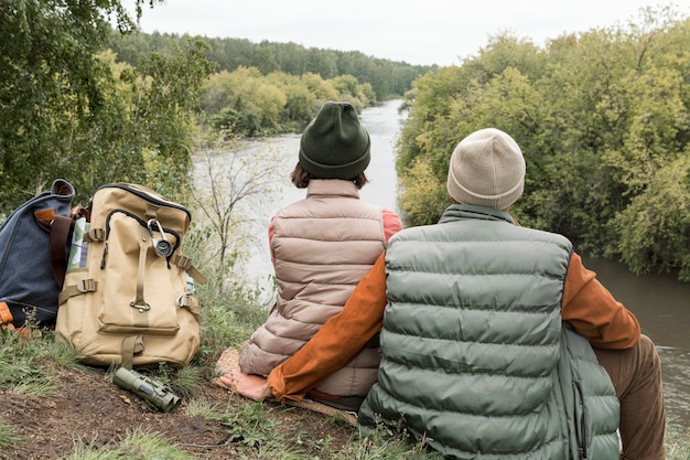 Couple assis sur le sol en regardant la rivière