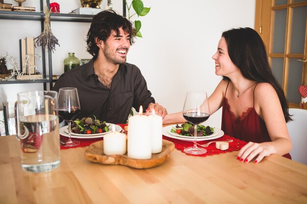Couple assis à une table à manger en souriant