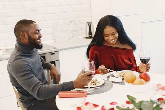 Couple assis à table, prendre un repas, parler et rire le jour de la Saint-Valentin