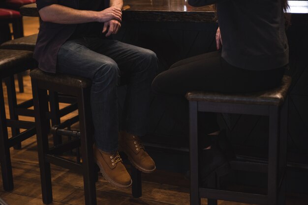 Couple assis sur un tabouret au comptoir du bar