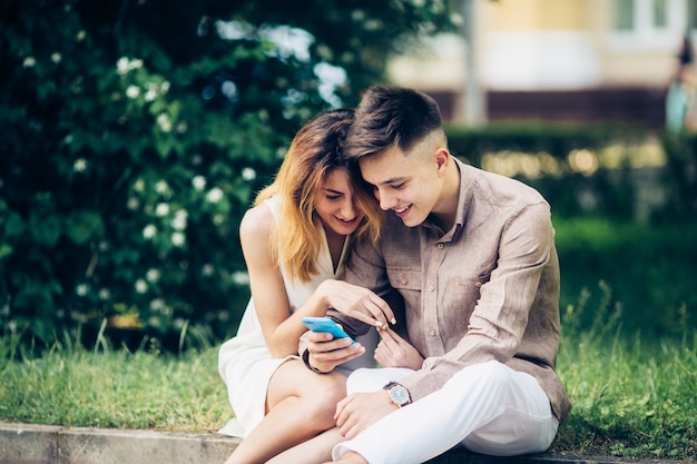 Couple assis et utilisant un smartphone