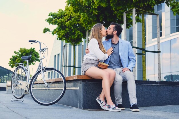 Couple attrayant à une date après une balade à vélo dans une ville. Un homme embrassant une femme.