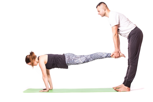 Couple attrayant faisant du yoga ensemble sur fond blanc