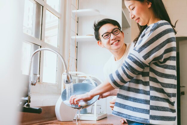 Couple attrayant mari et femme famille asiatique Laver la vaisselle avec le sourire et le bonheur dans le concept de famille de maison de cuisine