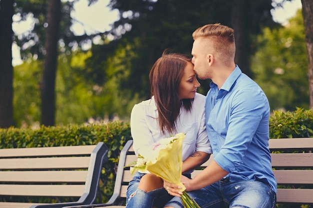 Couple attrayant à un rendez-vous. Un homme offre un bouquet de fleurs à sa petite amie.