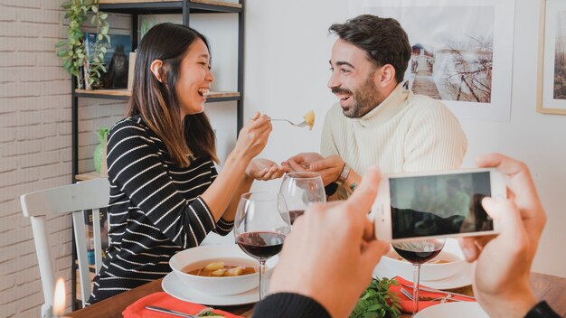 Couple au dîner de Noël à travers un smartphone