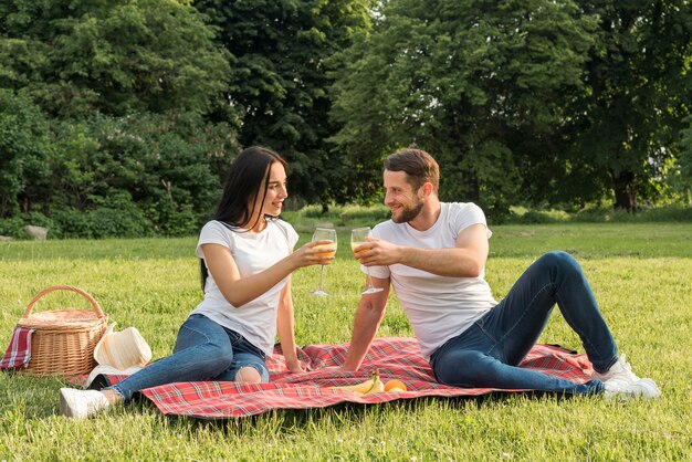 Couple ayant du jus d&#39;orange sur une couverture de pique-nique