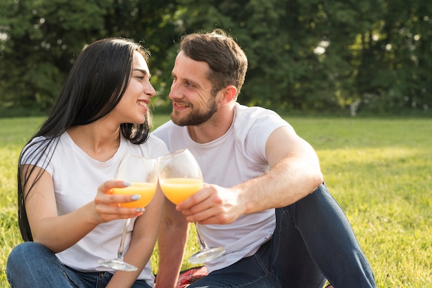 Couple ayant du jus d&#39;orange sur une couverture de pique-nique