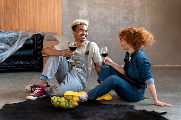 Couple ayant du vin ensemble après avoir emménagé dans leur nouvelle maison