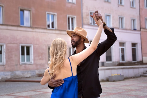 Photo gratuite couple ayant un spectacle de danse latine dans la ville