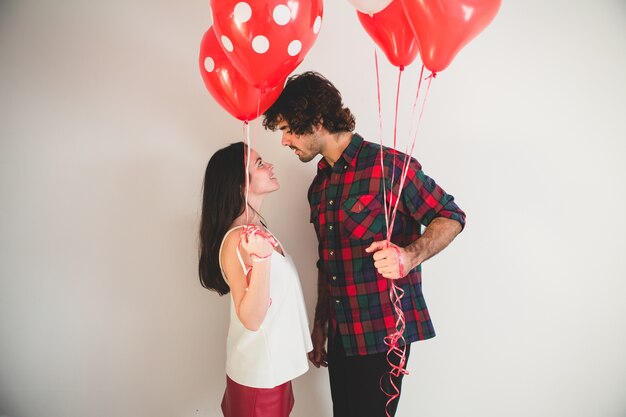 Couple avec des ballons dans les mains en regardant les uns les autres