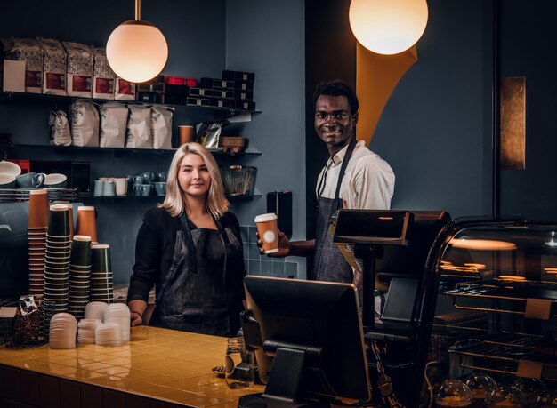 Couple barista debout derrière un comptoir dans le café. Concept d'entreprise de café