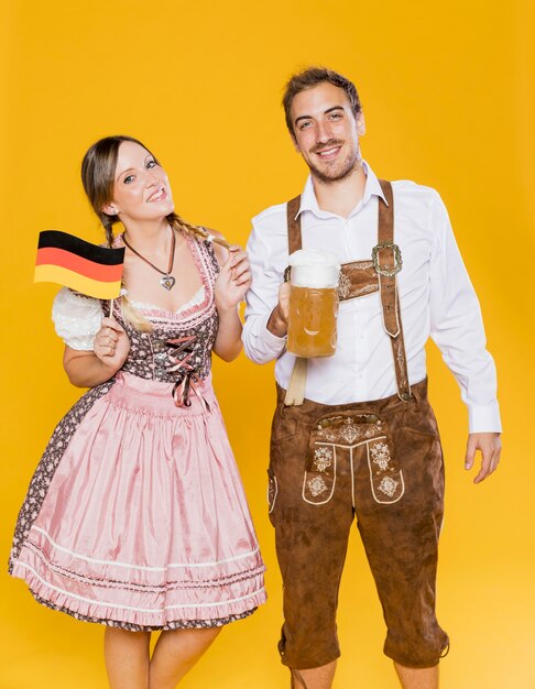Couple bavarois traditionnel avec drapeau et bière