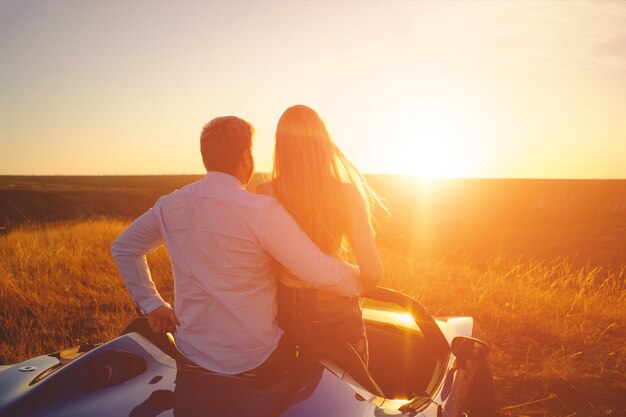 Couple de bonheur reste dans la nouvelle voiture de sport