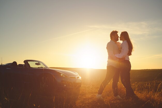 Couple de bonheur reste près de la nouvelle voiture de sport