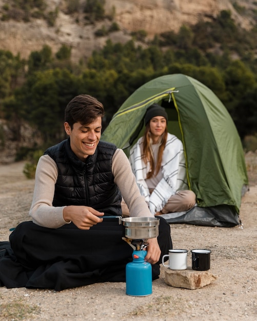 Photo gratuite couple camping homme cuisine