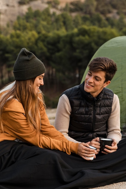 Photo gratuite couple camping et parler autour d'une tasse de thé