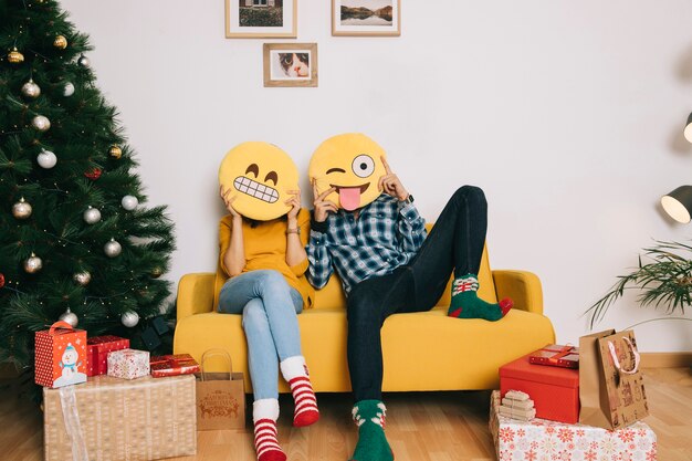 Couple sur le canapé avec des émoticônes