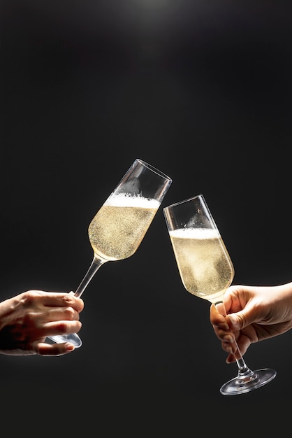 Couple célébrant avec champagne sur fond sombre