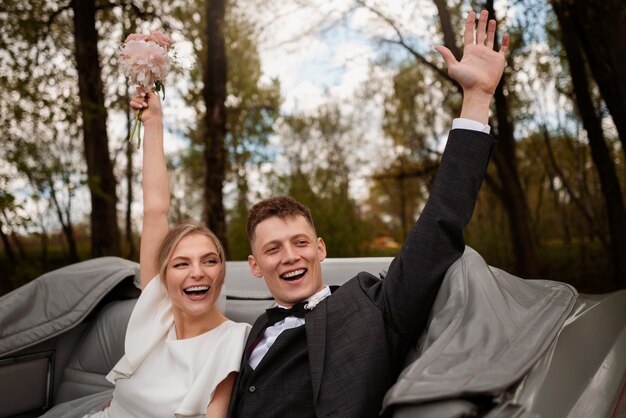 Couple célébrant dans leur voiture juste mariée