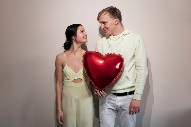 Photo gratuite couple célébrant la saint valentin avec un ballon en forme de coeur