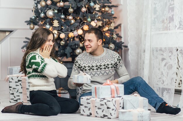 Le couple charmant en regardant les cadeaux