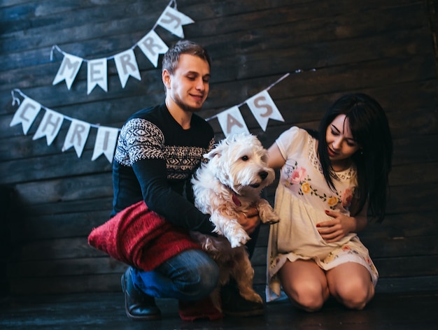 Photo gratuite couple avec chien posant en studio