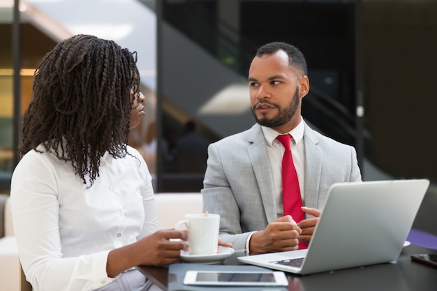 Couple de collègues regardant et discutant du contenu