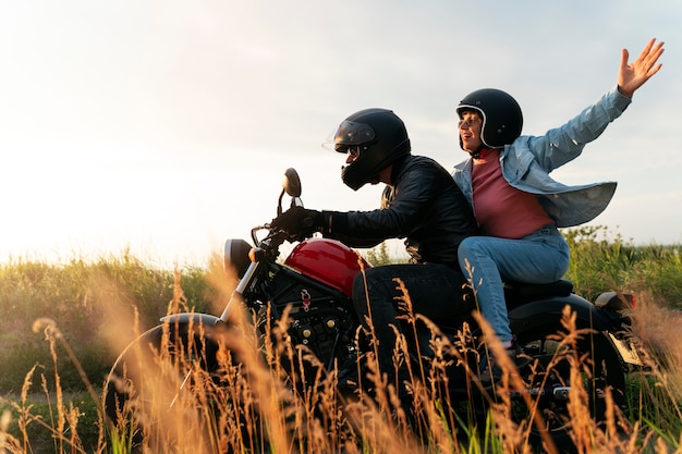 Photo gratuite couple conduisant une moto autour d'un magnifique paysage