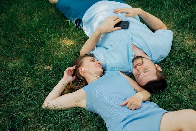 Couple, coucher herbe, à, écouteurs