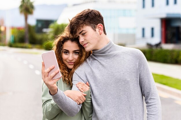 Couple coup moyen prenant selfie à l'extérieur