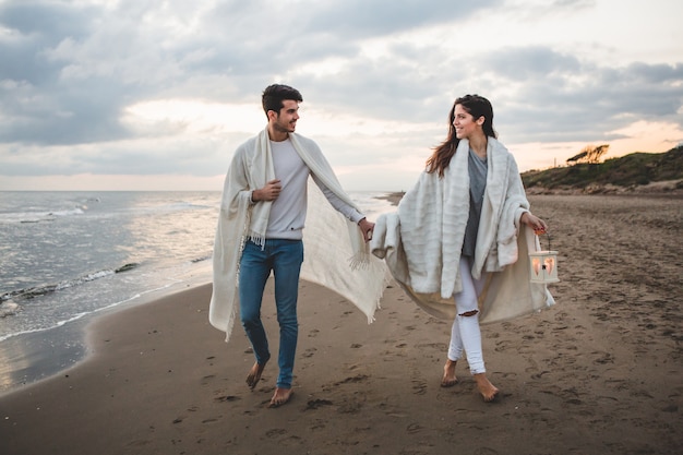 Photo gratuite couple avec des couvertures blanches et une bougie