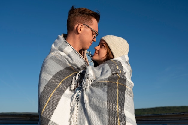 Photo gratuite couple dans une attitude affectueuse portant une couverture à carreaux