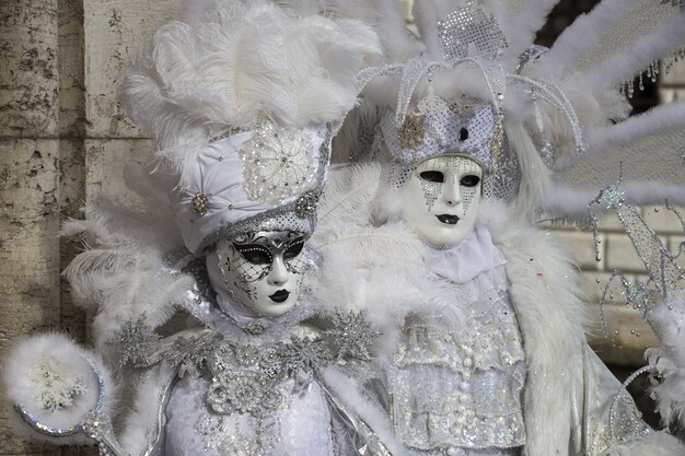Couple dans de belles robes et masques traditionnels de Venise pendant le carnaval de renommée mondiale