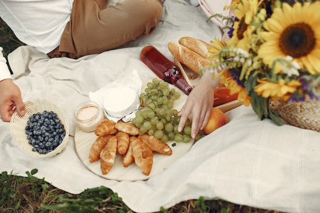 Couple dans un champ. Brunette en robe blanche. Paire assis sur l'herbe.