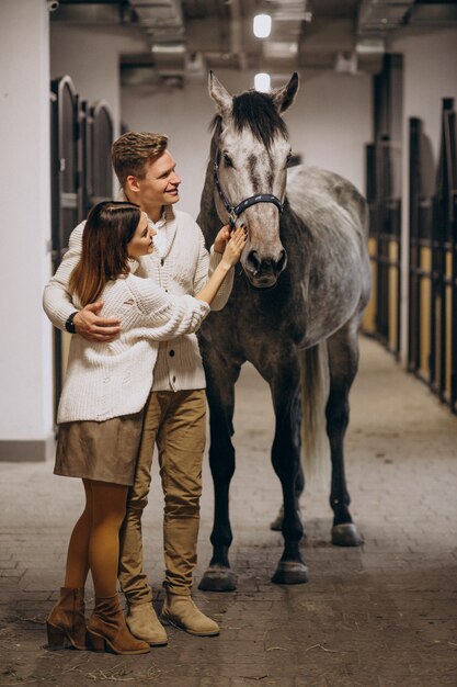 Couple dans l&#39;écurie avec cheval