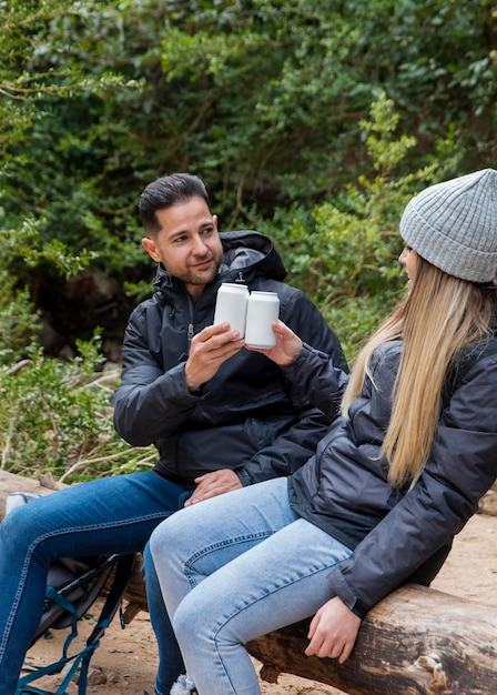 Photo gratuite couple dans la nature, boire des boissons