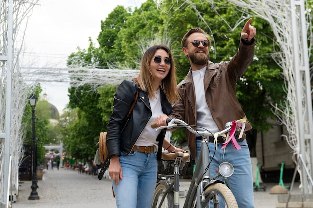 Couple dans des vestes en cuir synthétique marchant à l'extérieur avec des vélos