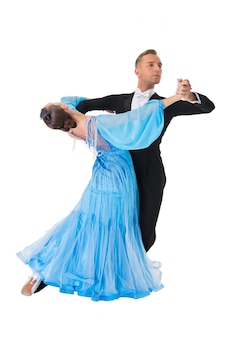 Couple de danse de salon dans une pose de danse isolé sur fond blanc. danseurs professionnels sensuels de salle de bal dansant la valse, le tango, le slowfox et le quickstep. juste danser. couple balrrom en robe bleue.