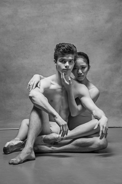 Couple de danseurs de ballet posant sur gris