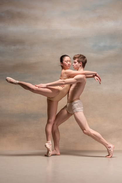 Couple de danseurs de ballet posant sur gris