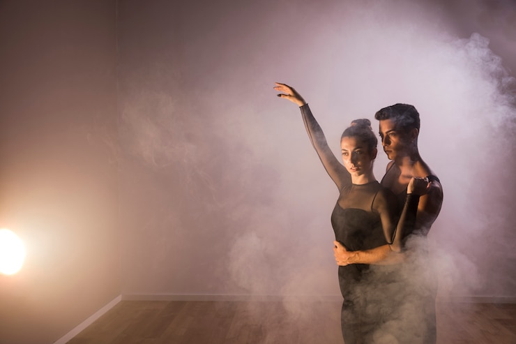 Photo gratuit couple de danseurs moyen en fumée