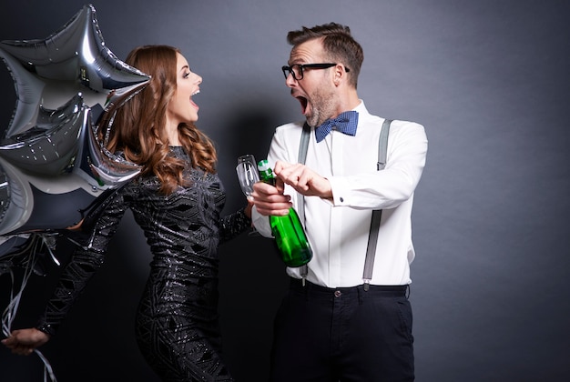 Photo gratuite couple débouche une bouteille de champagne