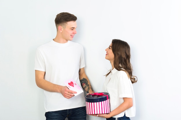 Couple debout avec cadeau et carte de voeux