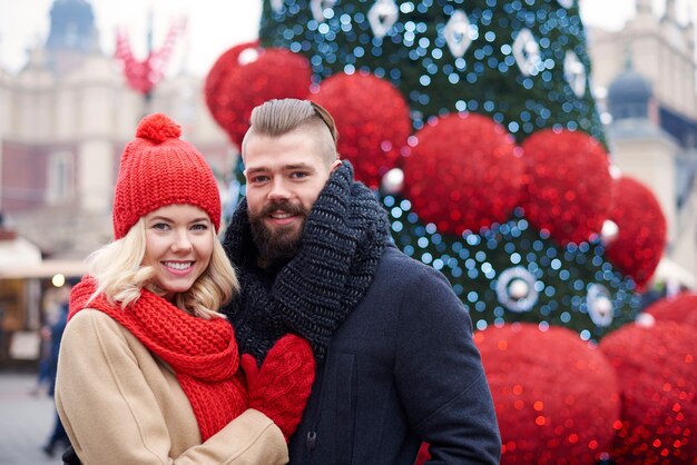 Couple debout à côté de l'arbre de Noël