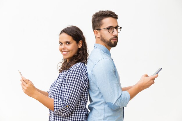 Couple, debout, dos à dos, utilisation, cellphones