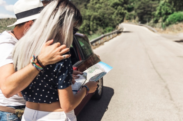 Photo gratuite couple debout sur une route droite en regardant la carte