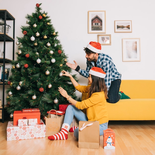 Couple, décorer le sapin de Noël à la maison